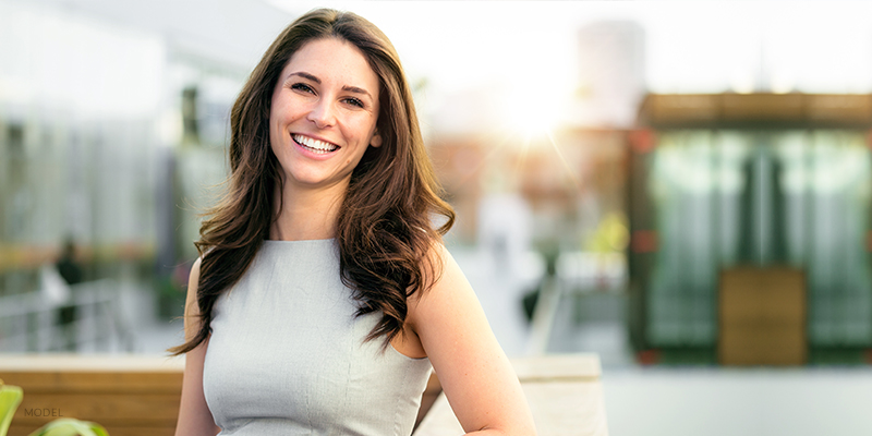 Smiling Female with Small Breasts Standing Outside