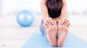 Woman Stretching Legs on Yoga Mat